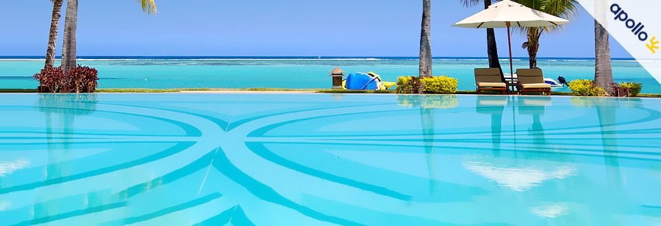 Tropiskt resort med en pool, palmer, solstolar och havsutsikt under en klarblå himmel.