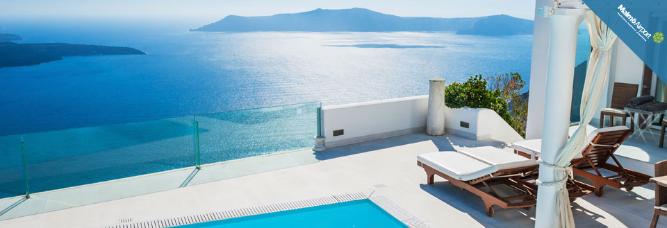Bilden visar en lyxig terrass med en infinitypool som har utsikt över det azurblå havet.