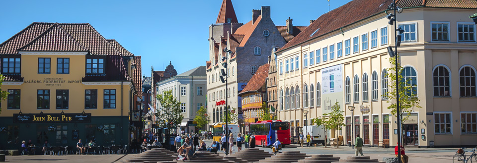 Nytorv og Boulevarden i Aalborg med byggnader, människor som går, och en röd buss.
