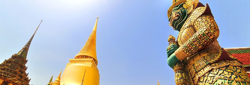 Grand Palace i Bangkok gyllene spiror och en stor utsmyckad staty.