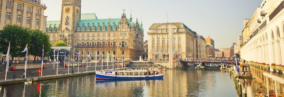 Bilden visar Spree Floden i Berlin med båtar, omgiven av historiska byggnader och flaggor.