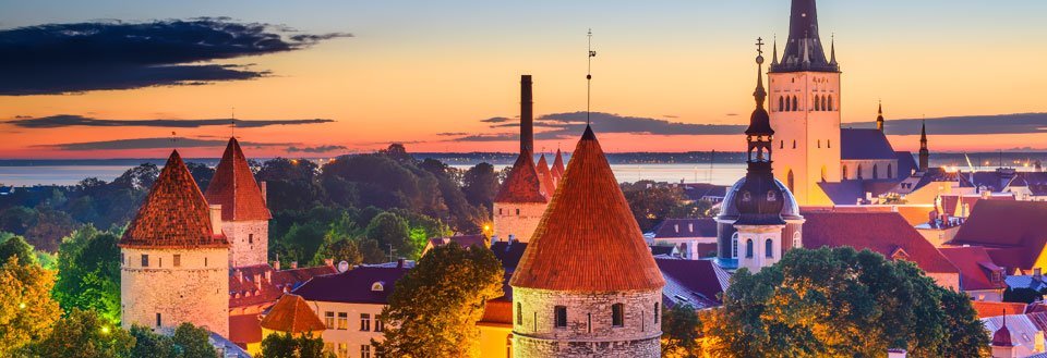 Tallinn vid solnedgången med torn och kyrkspiror, mot en himmel i färgglada nyanser.