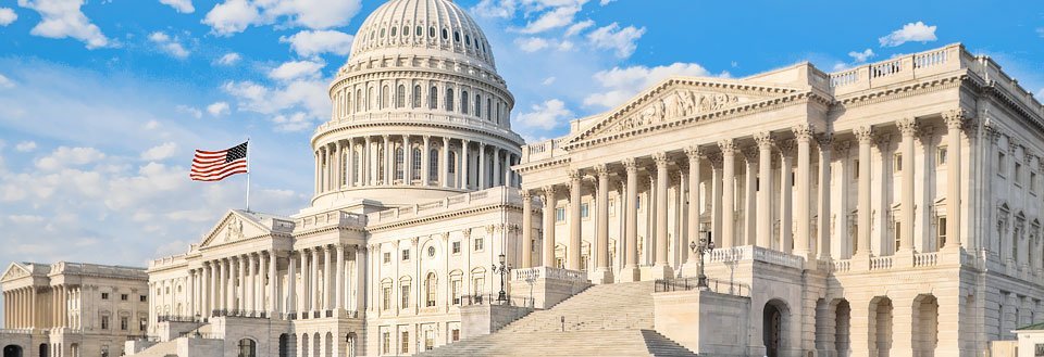 Den magnifika vita byggnadskomplexet som huser den amerikanska kongressen, mot en klarblå himmel i Washington D.C.