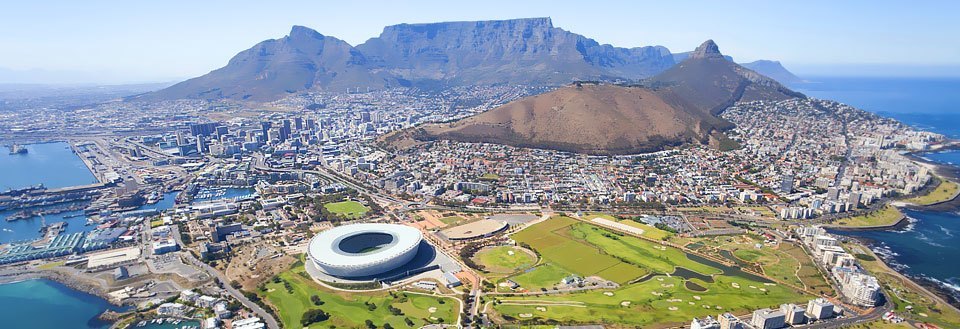 Panoramavy över Cape Town med en arena, hamnanläggningar och ett berg i bakgrunden.