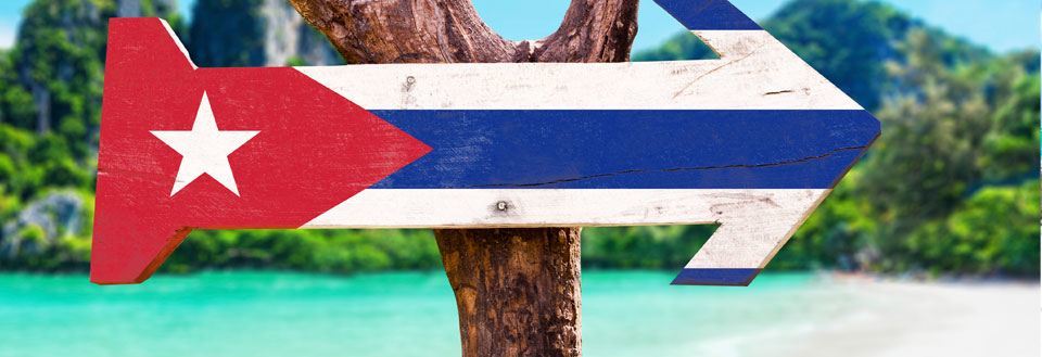 Vägvisningsskylt formad som en pil i de kubanska flaggans färger.