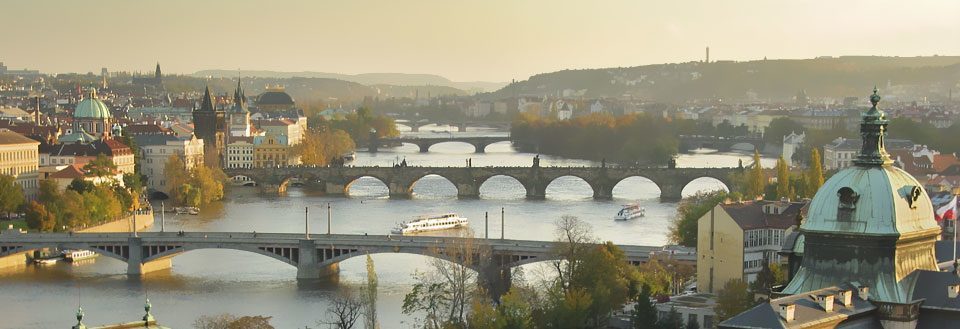 Prags silhuett med flera broar över floden Vltava i det gyllene kvällsljuset.