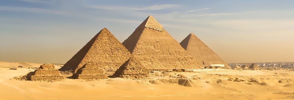 De storslagna pyramiderna i Giza under en klar himmel, omgiven av öken.