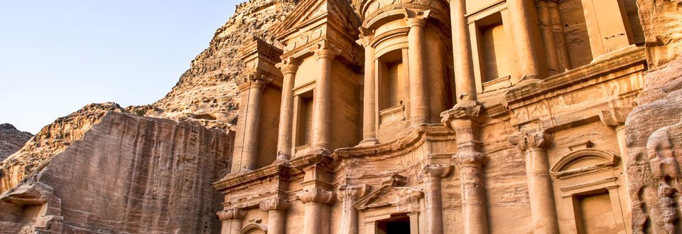 Den antika och berömda fasaden av ett tempel uthugget i klippa Petra i Jordan.